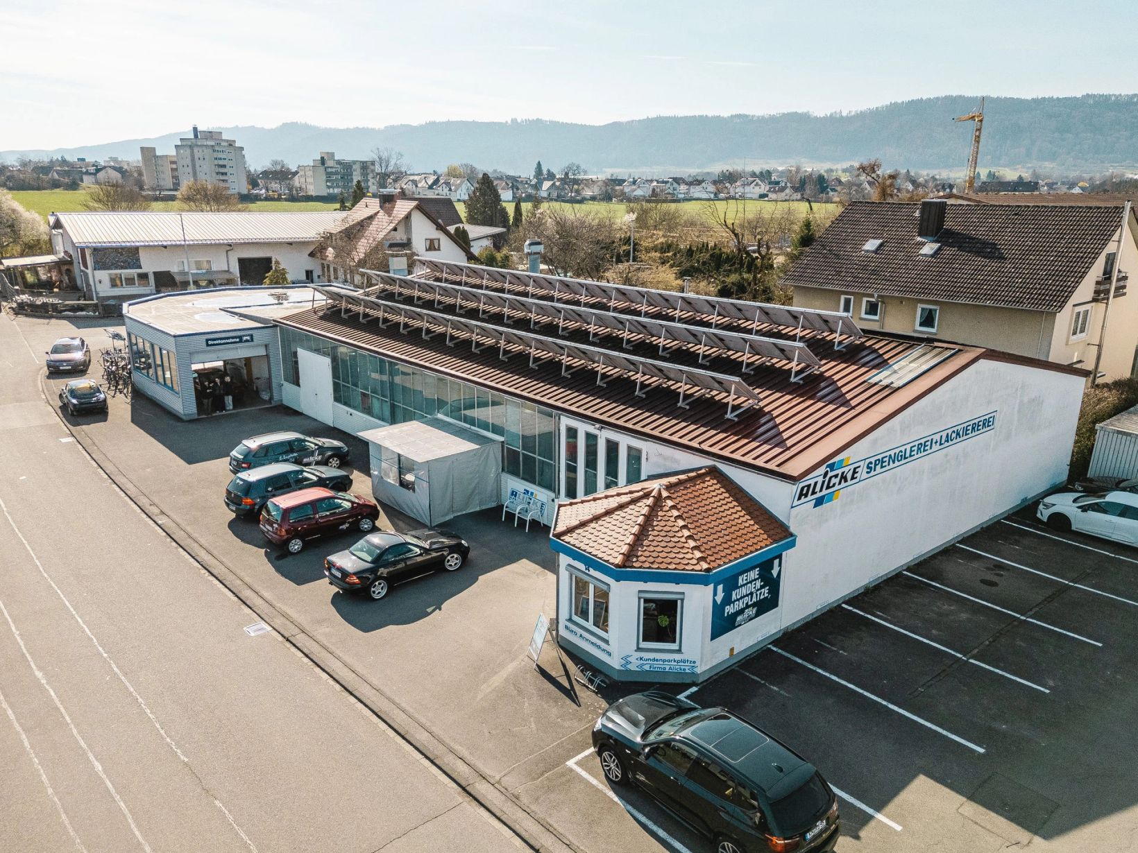 Luftaufnahme des Firmengebäudes der Alicke GmbH mit Solardach und Parkplatz